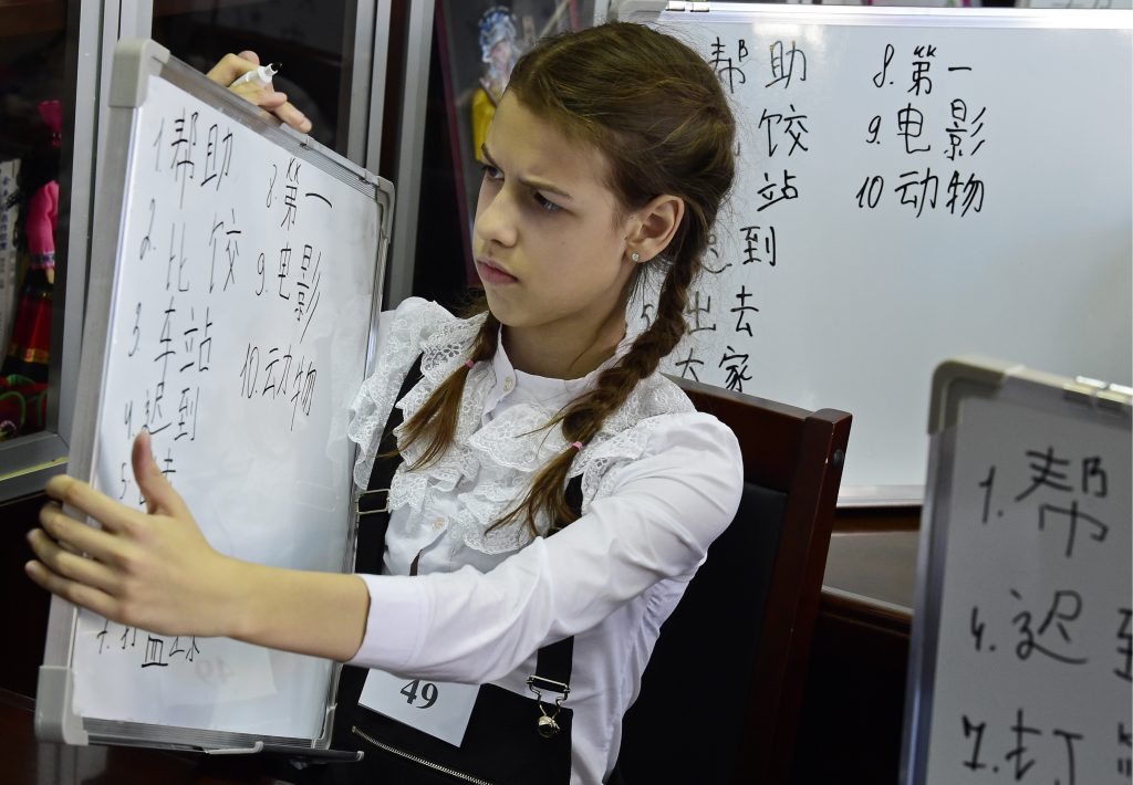 Юная финалистка первого тотального диктанта по китайскому языку для школьников в Институте Конфуция во Владивостоке сосредоточенно оценивает проделанную сложную работу