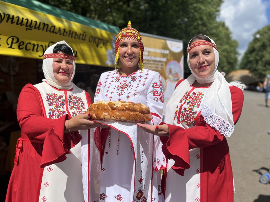Участницы праздника Анна Федорова, Надежда Семенова и Наталья Купцова (слева направо) угощают чувашским караваем